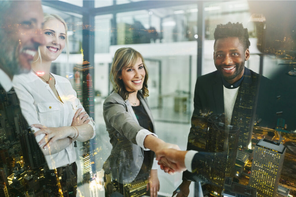 Businesspeople shaking hands inside a modern office setting